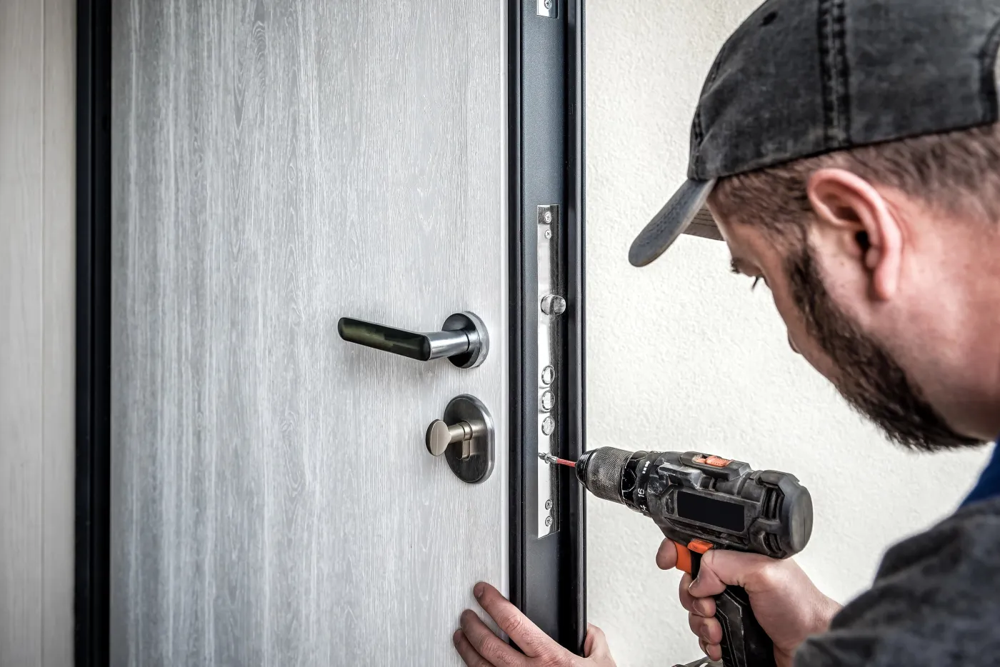 Serrurier fixant une serrure renforcée sur une entrée de pavillon du vieux bourg de Limay (78520)